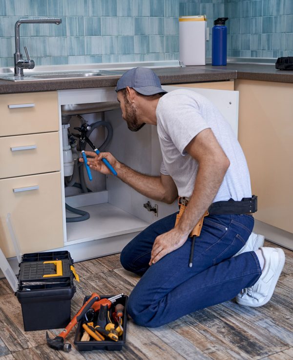 young-caucasian-male-worker-fixing-tubes-under-kit-2022-02-22-05-13-40-HLW4XHF.jpg